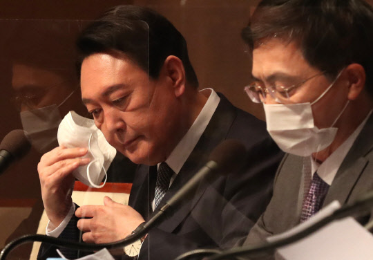 윤석열 국민의힘 대선후보가 14일 오전 서울 중구 프레스센터 국제회의장에서 열린 관훈클럽 초청 토론회에서 발언하기 위해 마스크를 벗고 있다.국회사진기자단·연합뉴스